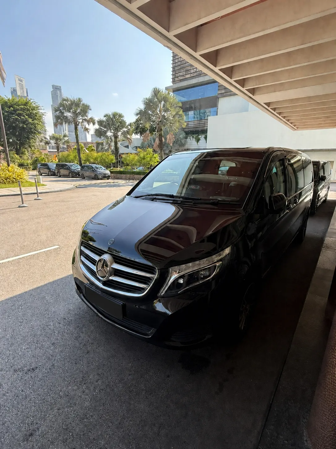 Chauffeur waiting beside an Executive MPV at Raffles Place, Singapore